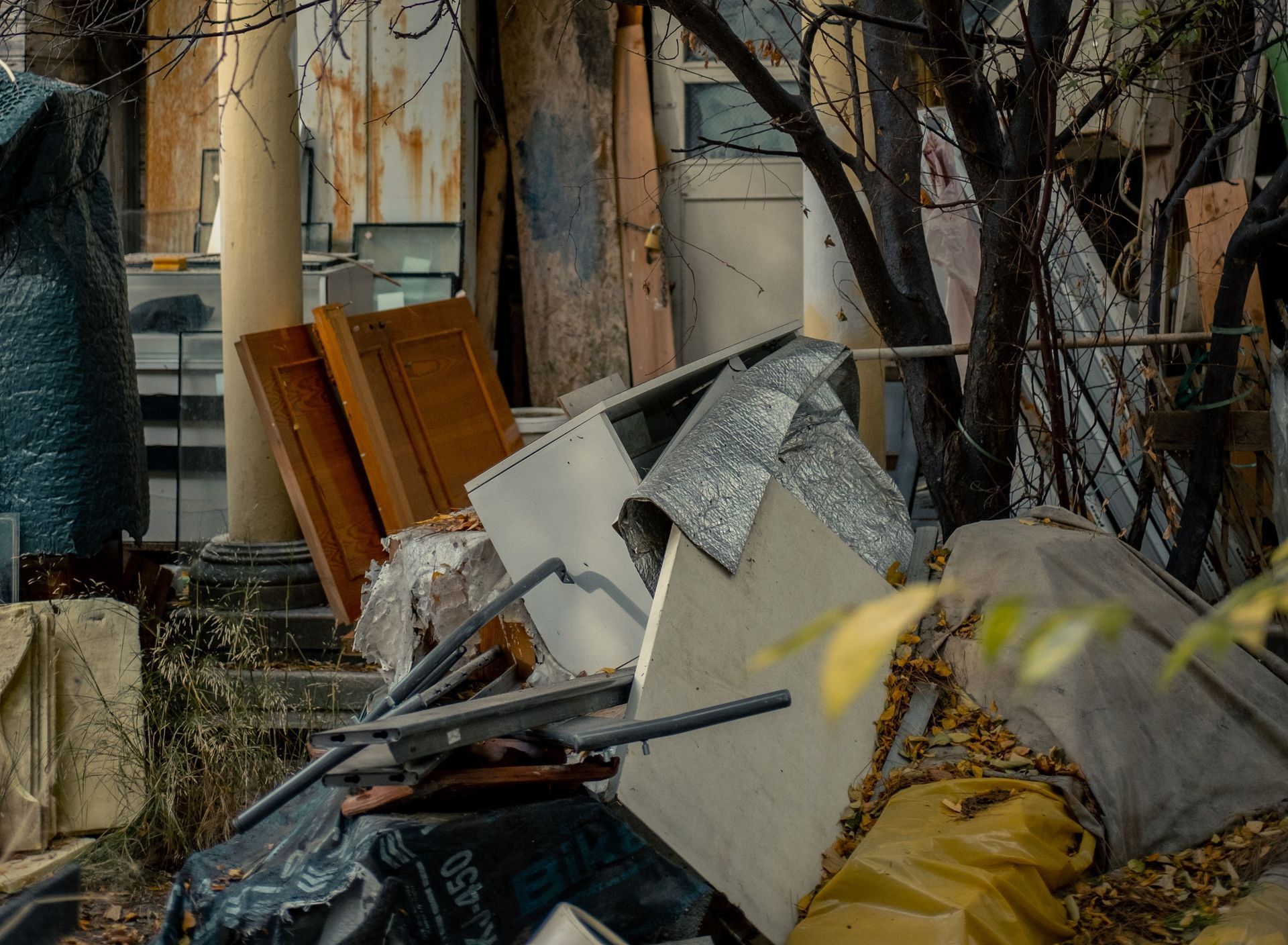 Abandoned building overgrown with trees and debris, capturing urban decay.
